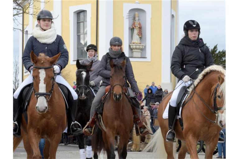 Beim traditionellen Silvesterritt ziehen Reiterinnen ab einer Kapelle vorbei. Foto: Stefan Puchner/dpa/Archivbild