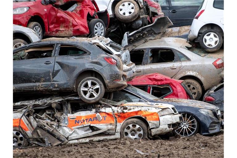 Beim Unwetter zerstörte Autos sind in Bad Neuenahr-Ahrweiler auf einem provisorischen Schrottplatz gestapelt. Foto: Marius Becker/dpa