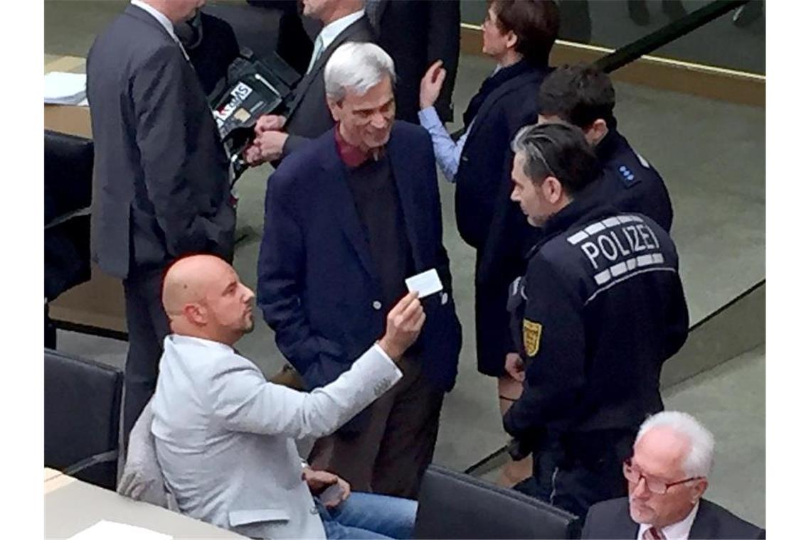 Beispielloser Eklat: Stefan Räpple (sitzend, l.), AfD-Abgeordneter im Landtag von Baden-Württemberg, setzt sich mit Polizisten auseinander. Foto: Nico Pointner