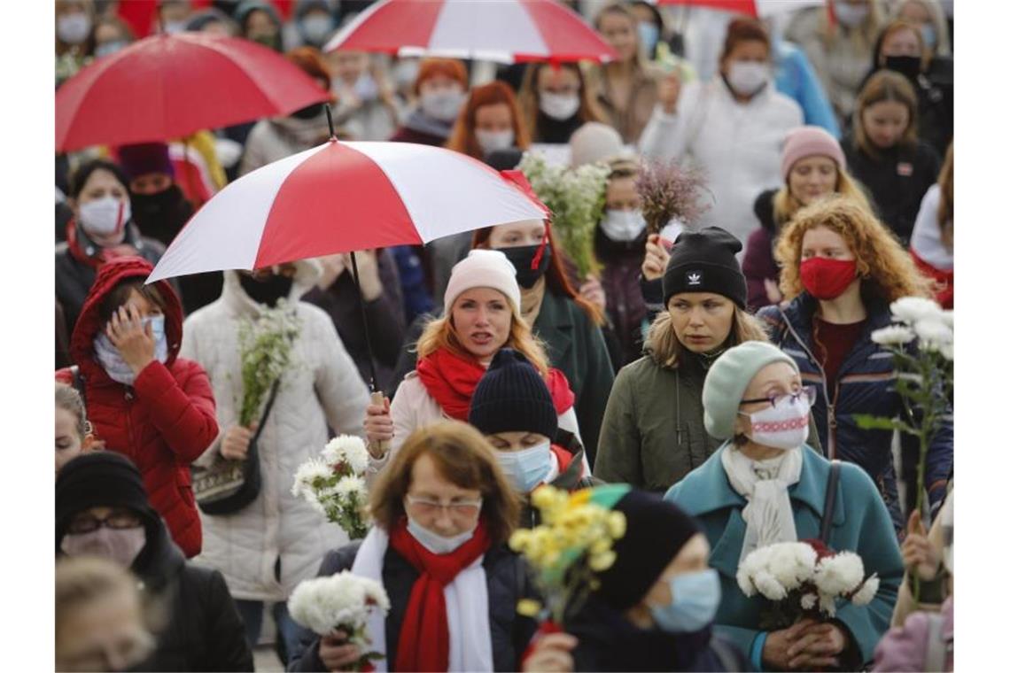 Belarussische Frauen mit Regenschirmen gehen weiter gegen die Ergebnisse der Präsidentschaftswahlen auf die Straße (Archiv). Foto: -/AP/dpa