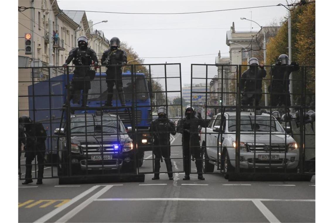 Belarussische Polizeibeamte blockieren während eines Protests eine Straße. Foto: Uncredited/AP/dpa