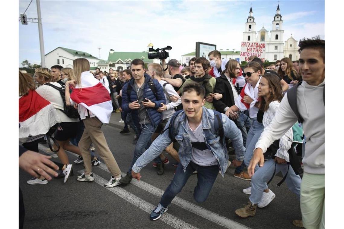Belarussische Studenten rennen bei einer Kundgebung vor der Heilig-Geist-Kathedrale in Minsk vor der Polizei weg. Foto: Uncredited/Tut.by/AP/dpa