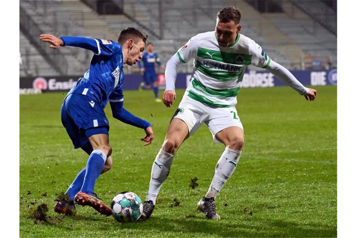 Benjamin Goller (l) vom Karlsruher SC und David Raum vom SpVgg Greuther Fürth kämpfen um den Ball. Foto: Uli Deck/dpa