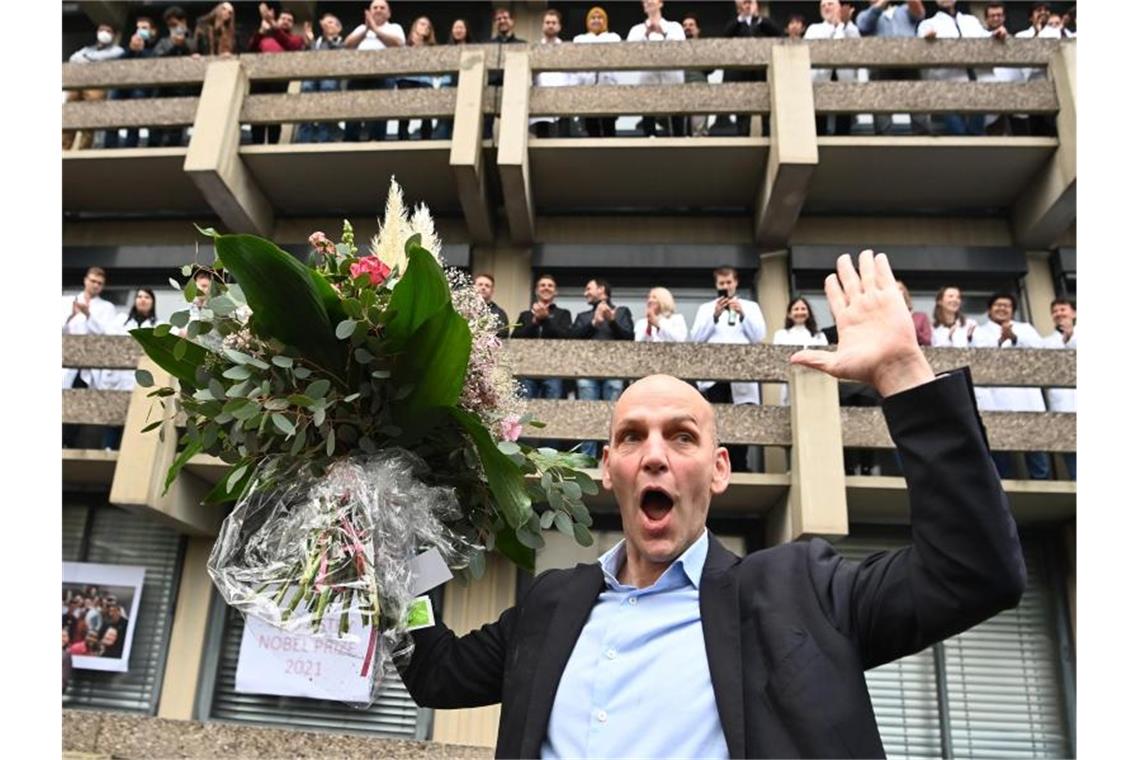 Benjamin List freut sich mit einem Blumenstrauß bei der Ankunft am Max-Planck-Institut (MPI) für Kohlenforschung. Foto: Federico Gambarini/dpa