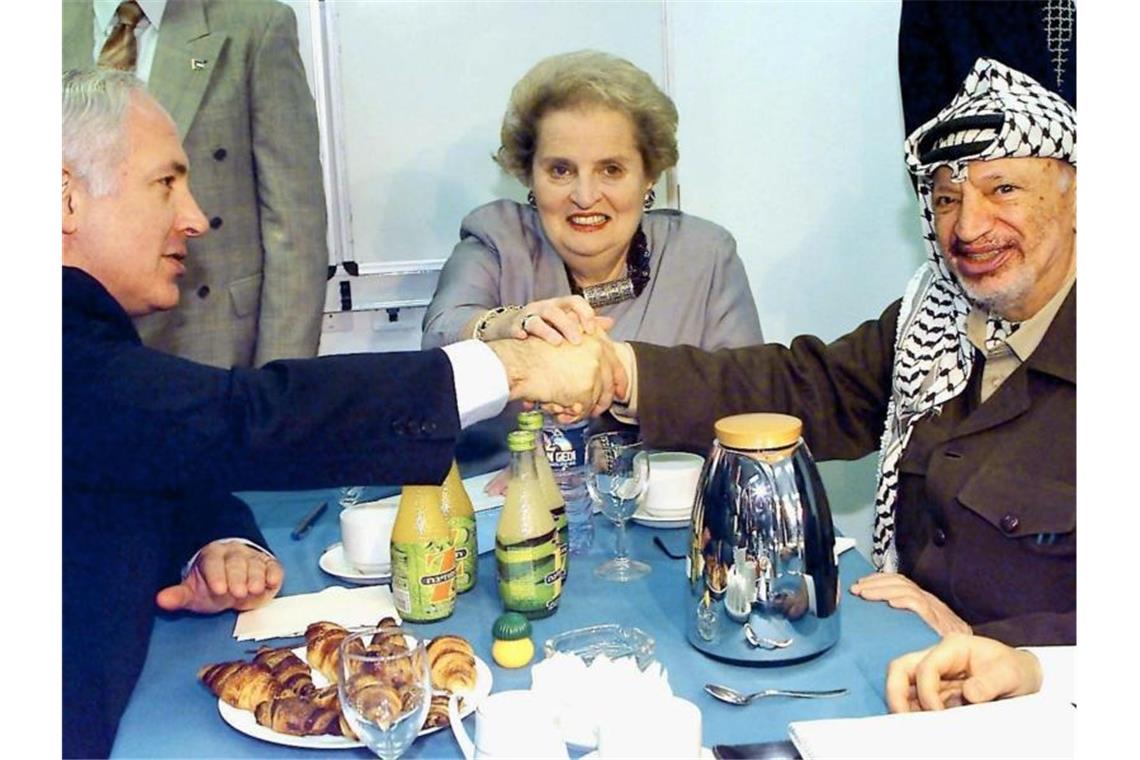 Frühere US-Außenministerin Madeleine Albright ist tot Benjamin Netanjahu, damals Ministerpräsident von Israel, Jassir Arafat, damals Palästinenserpräsident, und Albright reichen sich nach einem Treffen 1998 symbolisch die Hände. Foto: Jim Hollander/epa/dpa