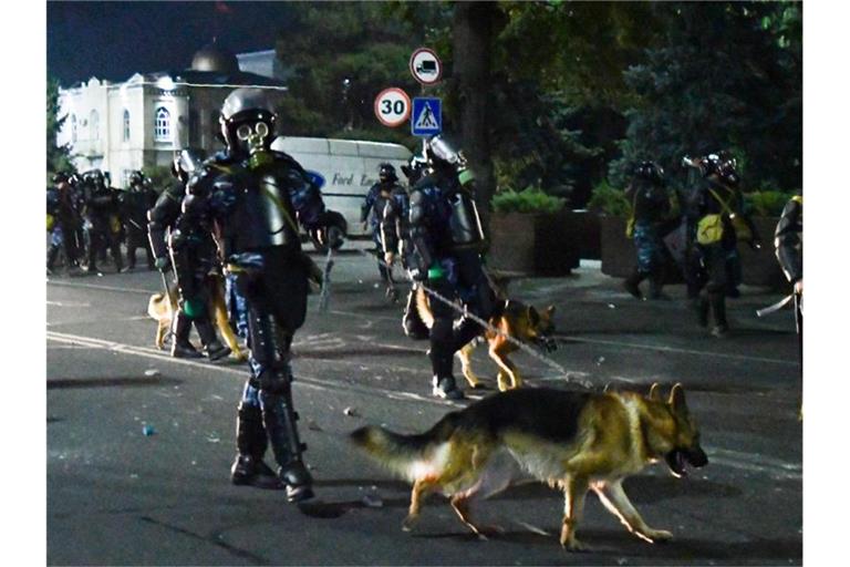 Bereitschaftspolizei mit Hunden zerstreut Demonstranten während einer Kundgebung gegen die Ergebnisse einer Parlamentsabstimmung. Foto: Vladimir Voronin/AP/dpa