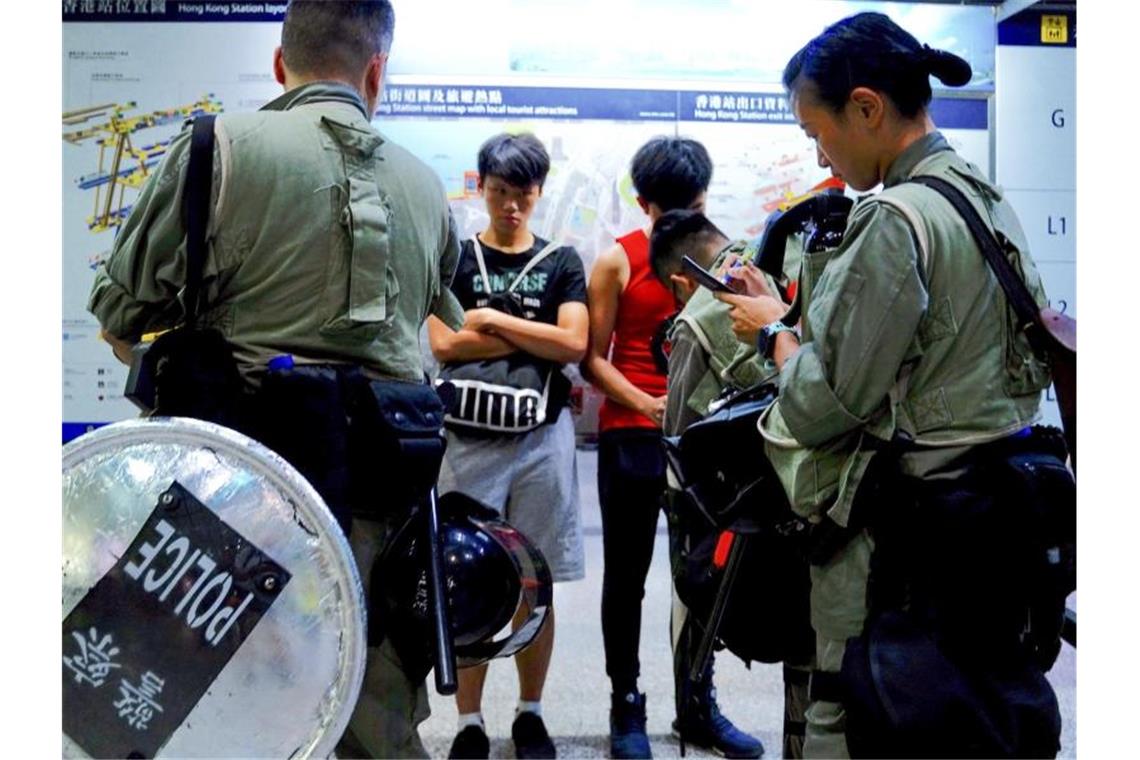 Bereitschaftspolizei überprüft am Hauptbahnhof des Flughafenzuges „Airport Express“ in der Innenstadt die Taschen der Passagiere. Foto: Vincent Yu/AP