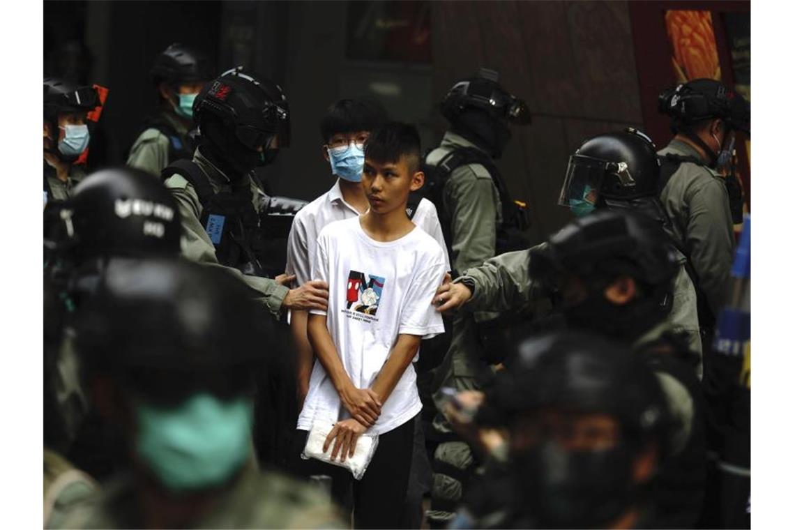 Peking: Volkskongress billigt Sicherheitsgesetz für Hongkong Bereitschaftspolizisten halten im Zentrum von Hongkong zwei junge Demonstranten fest. Foto: Kin Cheung/AP/dpa