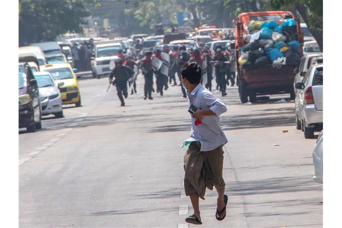 Bittere Bilanz am Jahrestag des Myanmar-Putsches Bereitschaftspolizisten rennen einem Demonstranten in Rangun hinterher. (Archivbild). Foto: Santosh Krl/SOPA Images via ZUMA Wire/dpa