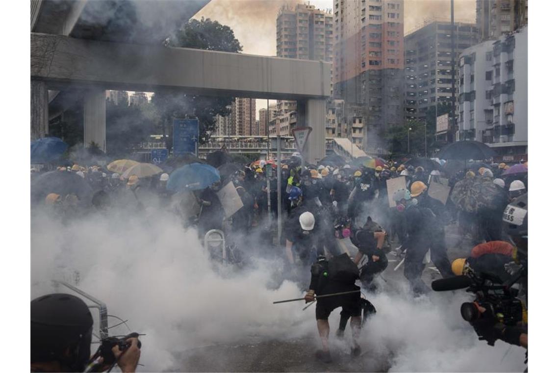 Hongkong: Zusammenstöße zwischen Polizei und Demonstranten Bereitschaftspolizisten stehen Demonstranten bei dem Protest im Bezirk Yuen Long gegenüber. Foto: Vincent Yu/AP