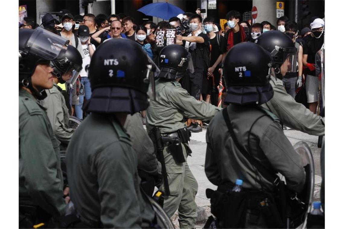 Bereitschaftspolizisten stehen Demonstranten bei dem Protest im Bezirk Yuen Long gegenüber. Foto: Vincent Yu/AP