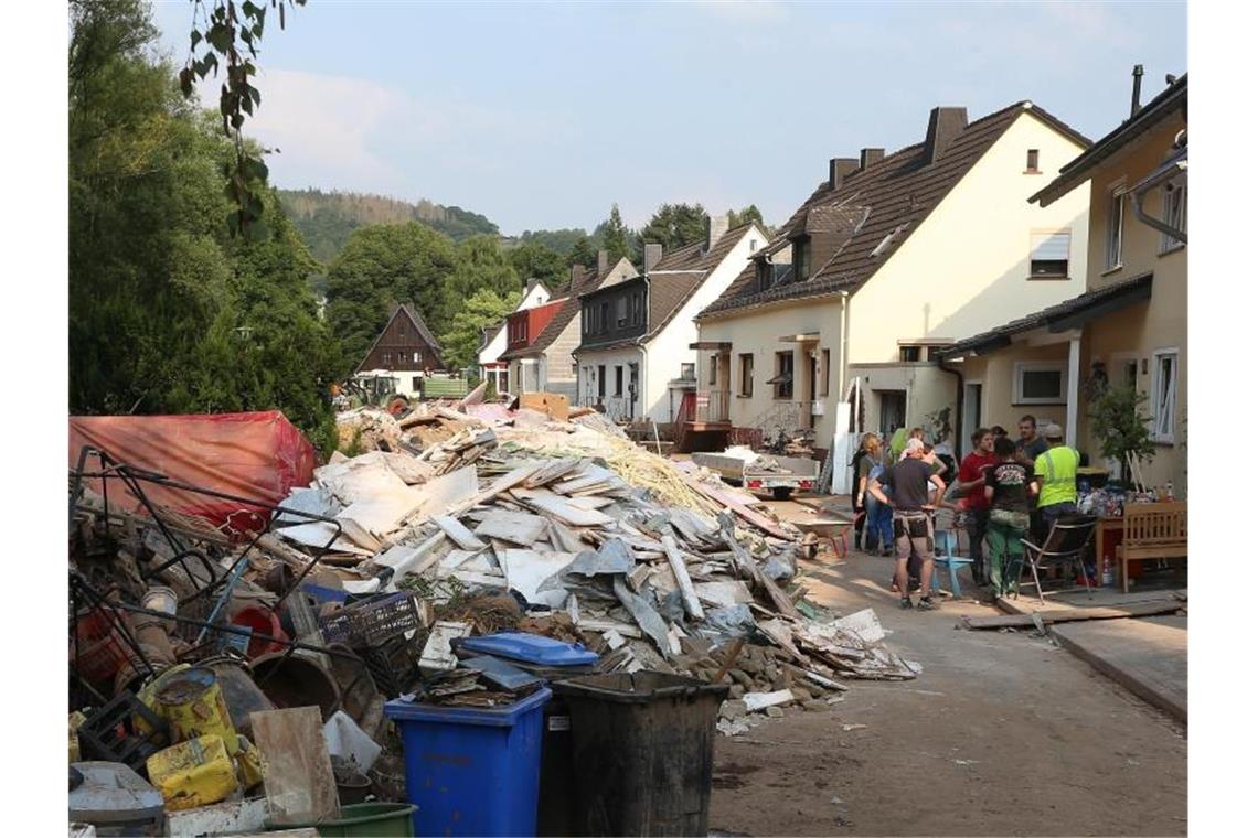 In den Katastrophengebieten droht neuer Starkregen Berge von Schutt und Müll auf einer Straße in Schleiden. Foto: David Young/dpa