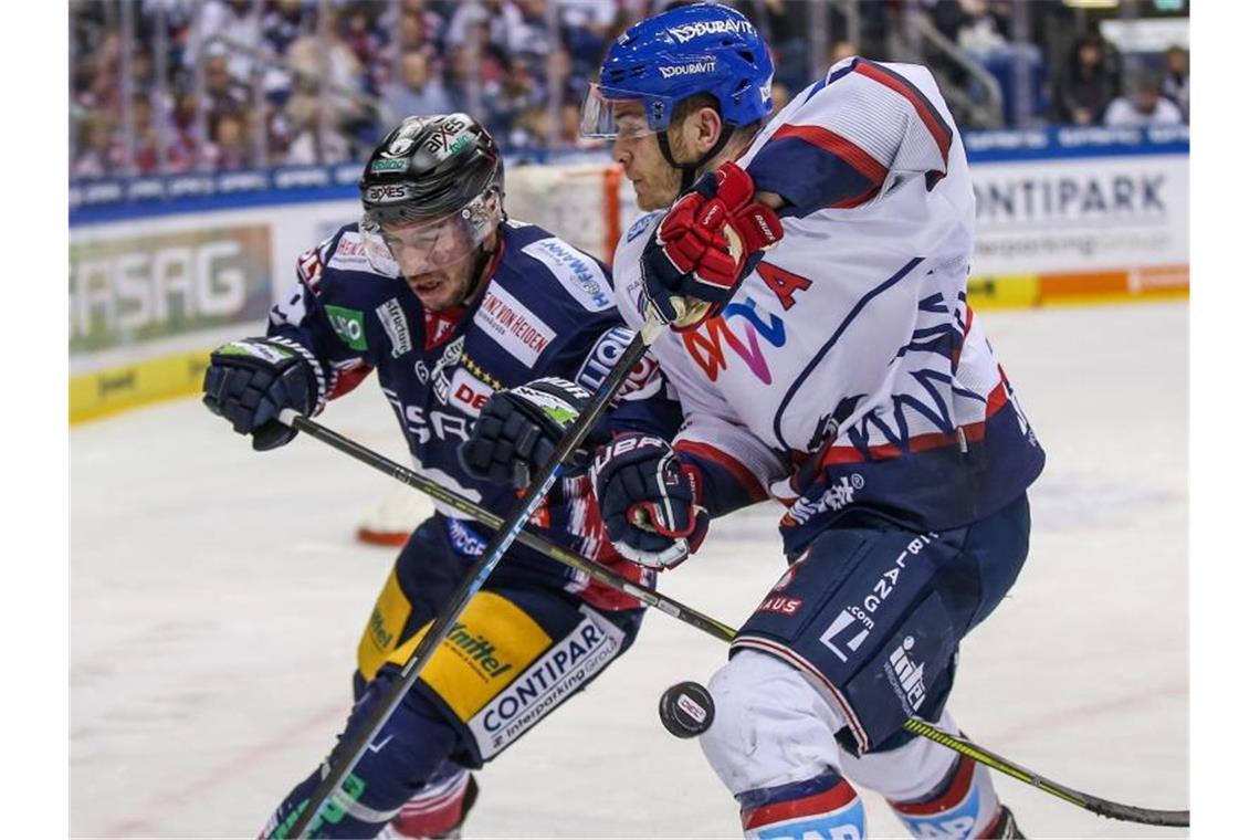 Berlins Florian Kettemer (l) kämpft gegen Ben Smith von Adler Mannheim um den Puck. Foto: Andreas Gora/dpa/Archiv