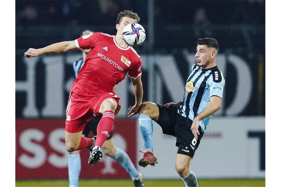Dank Awoniyi: Union ringt Waldhof in der Verlängerung nieder Berlins Kevin Behrens (l) und Mannheims Stefano Russo kämpfen um den Ball. Foto: Uwe Anspach/dpa