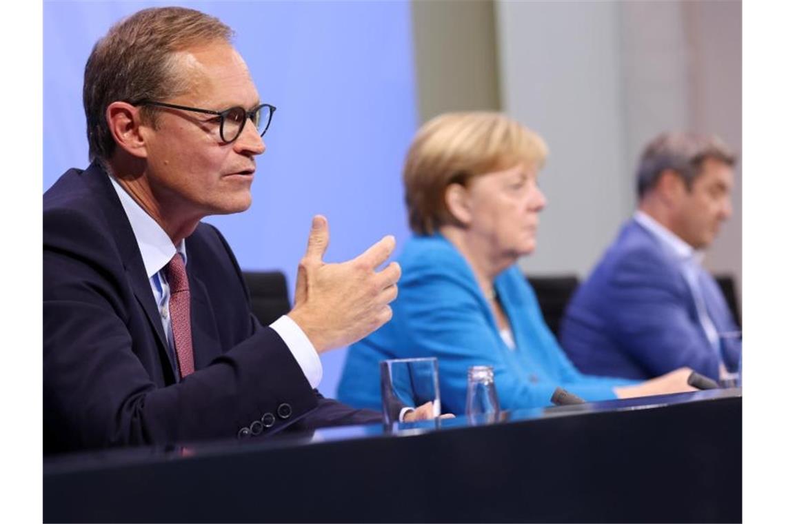 Bund hält vorerst an 3G-Regel fest Berlins Regierender Bürgermeister Michael Müller (l), Bundeskanzlerin Angela Merkel und der bayerische Ministerpräsident Markus Söder geben nach den Bund-Länder-Beratungen eine Pressekonferenz. Foto: Christian Mang/Reuters/Pool/dpa