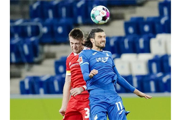 Berlins Robin Knoche (l) und Hoffenheims Florian Grillitsch kämpfen um den Ball. Foto: Uwe Anspach/dpa