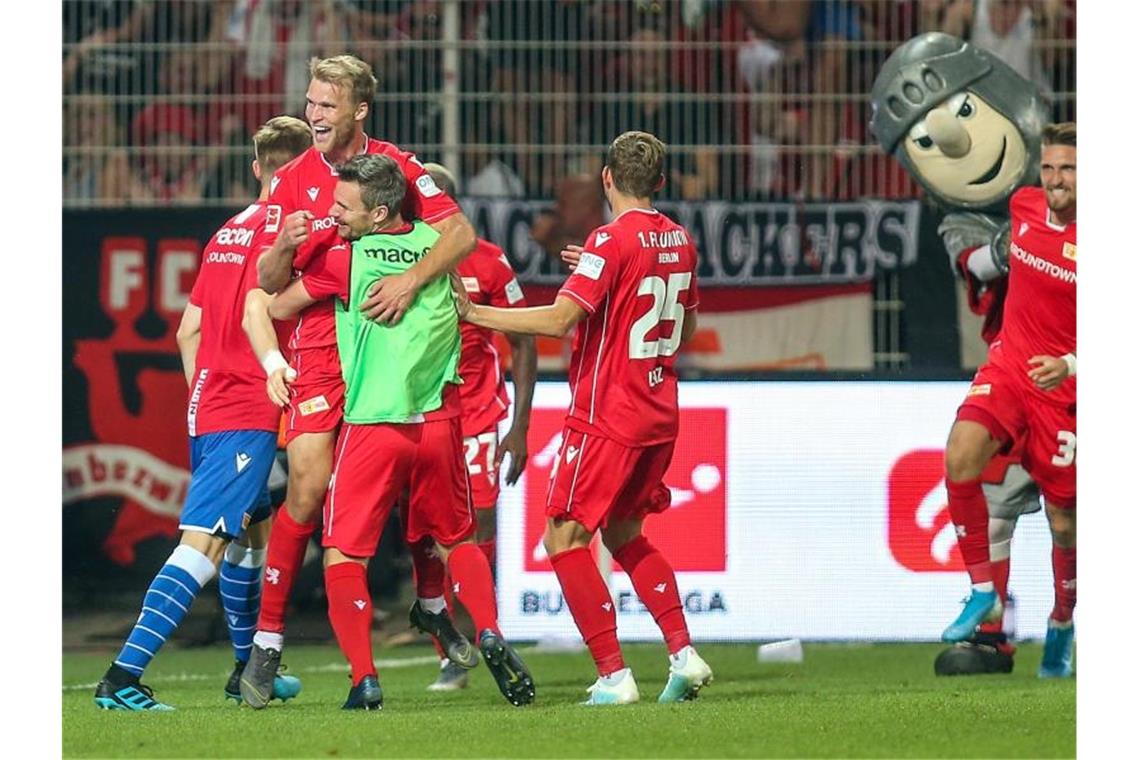 Dortmund patzt, Bayern mit Kantersieg, Schalke jubelt Berlins Sebastian Andersson (2.v.l) jubelt nach seinem Treffer zum 3:1 mit Teamkollegen und Maskottchen Ritter Keule. Foto: Andreas Gora