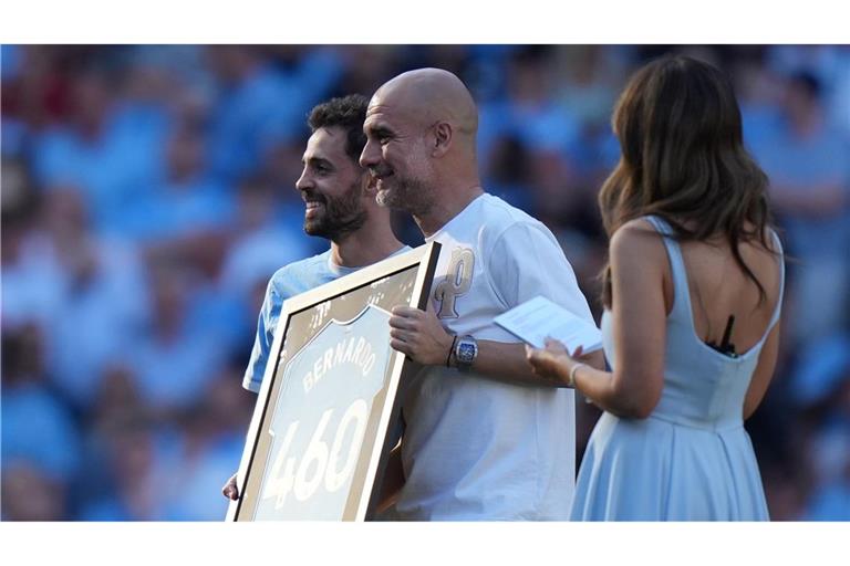 Bernardo Silva (l) und Trainer Pep Guardiola während einer Zeremonie nach ihrem letzten Spiel für Manchester City.