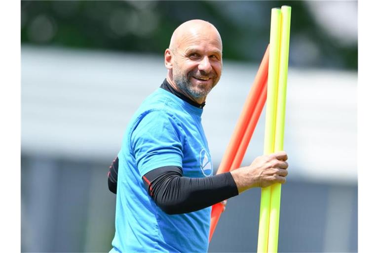 Bernhard Trares, Trainer von Waldhof Mannheim, steht mit farbigen Stangen auf dem Trainingsplatz. Foto: Uwe Anspach/Archivbild