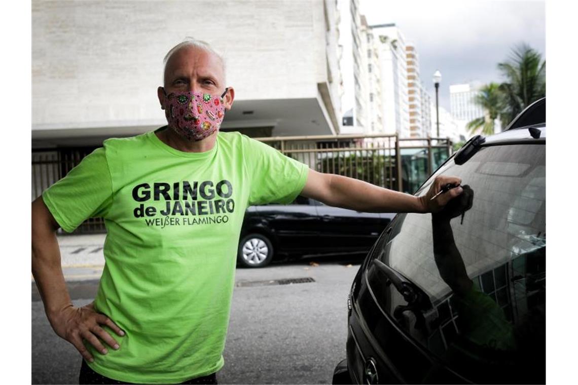 Bernhard Weber steht mit Mundschutzmaske neben seinem Wagen, bevor er sich auf den Weg in die Favela Rocinha macht. Foto: Ian Cheibub/dpa