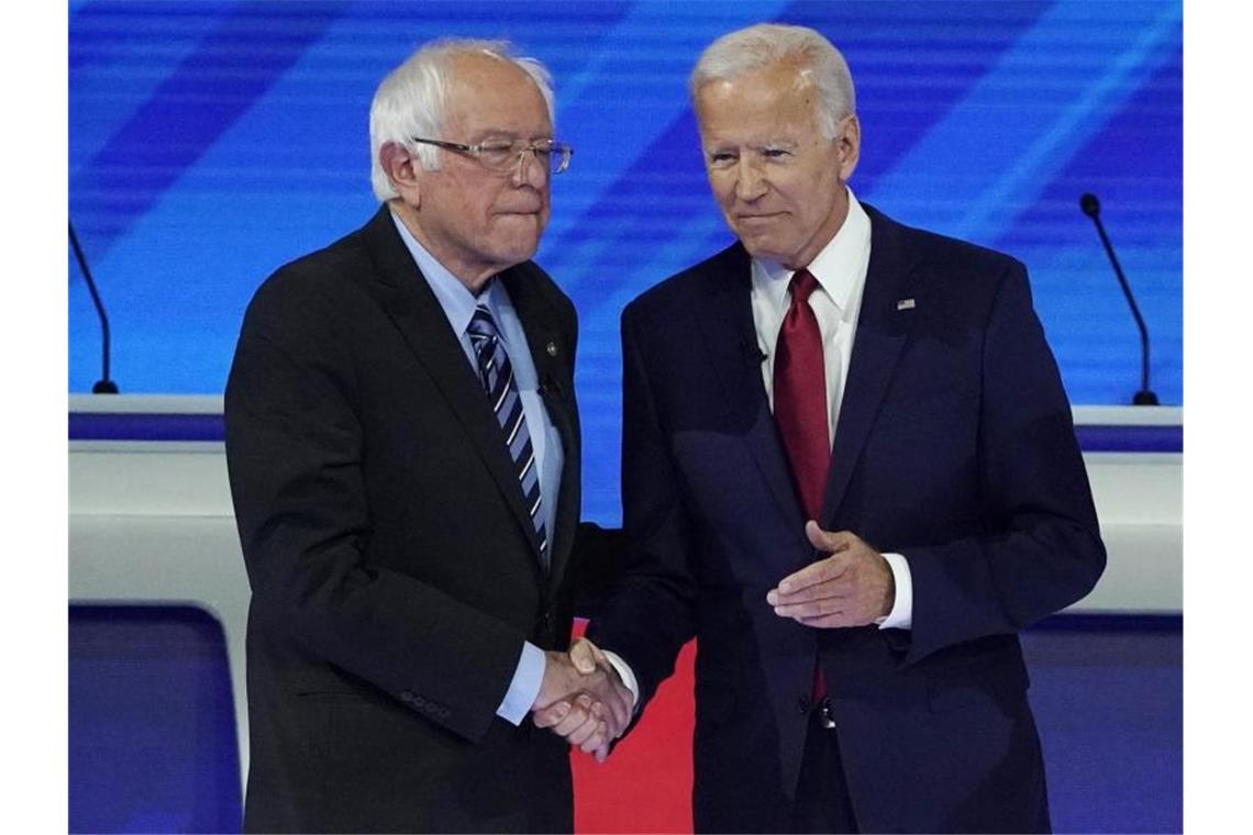 Bernie Sanders (L) und Joe Biden begrüßen sich zur dritten TV-Debatte. Foto: David J. Phillip/AP