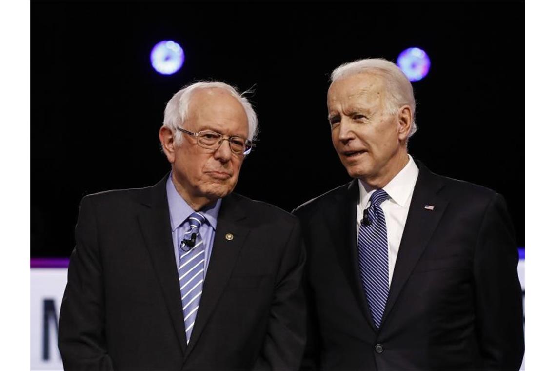 Bernie Sanders (l) und Joe Biden stehen im Februar während einer TV-Debatte nebeneinander. Foto: Matt Rourke/AP/dpa