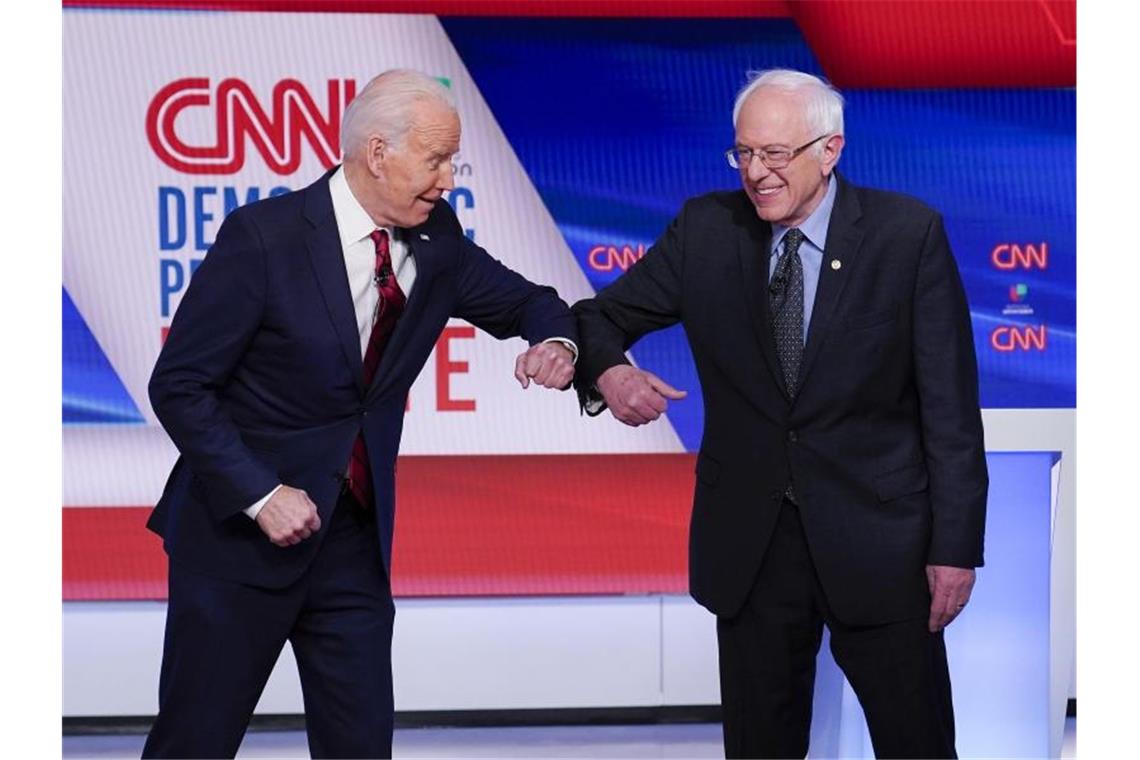 Bernie Sanders (r), und Joe Biden begrüßen sich mit ihren Ellenbogen. Foto: Evan Vucci/AP/dpa