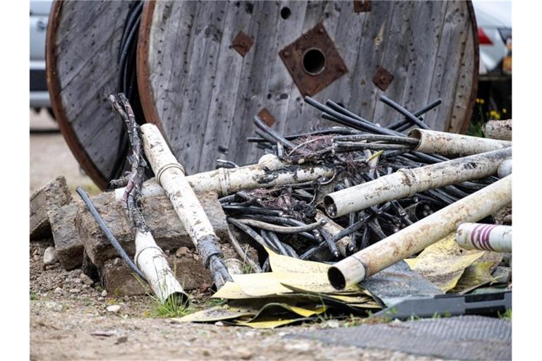Beschädigte Stromkabel liegen neben der Baustelle. Foto: Matthias Balk/dpa