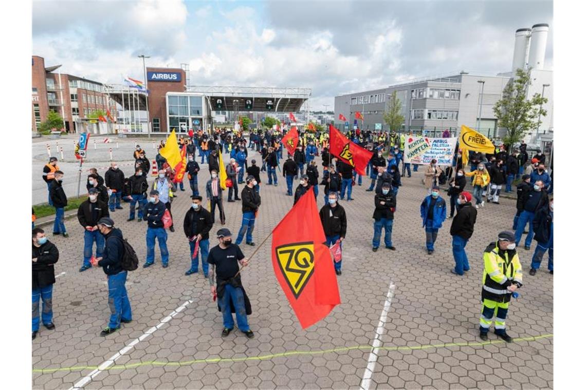 IG Metall und Airbus beginnen Gespräche über Konzernumbau Beschäftigte des Airbus-Werkes in Hamburg-Finkenwerder demonstrieren im Mai 2021 vor den Toren des Werksgeländes. In dem seit Monaten schwelenden Konflikt um den geplanten Konzernumbau sollen nun Verhandlungen zwischen der IG Metall und dem Flugzeugbauer beginnen. Foto: Daniel Reinhardt/dpa
