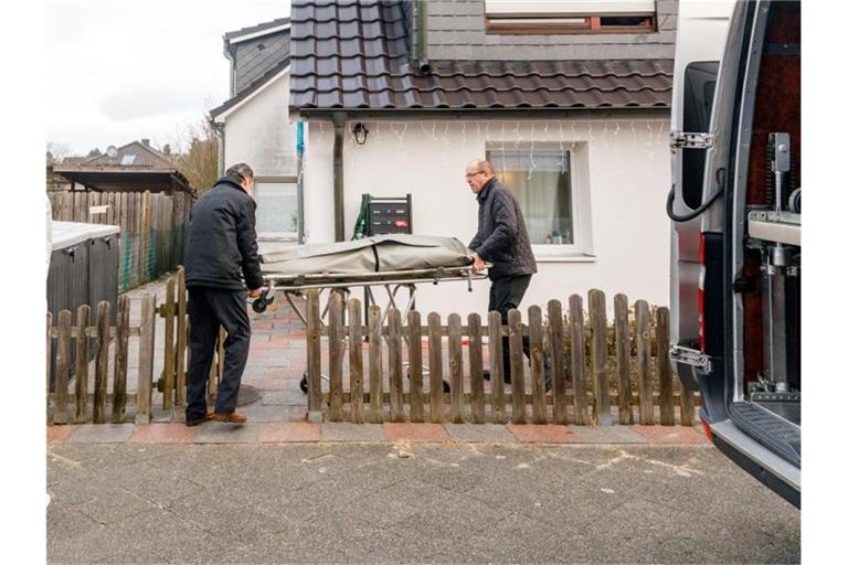 Bestatter bringen eine Trage mit einem Leichnam aus dem Wohnhaus in Glinde. Foto: Markus Scholz/dpa