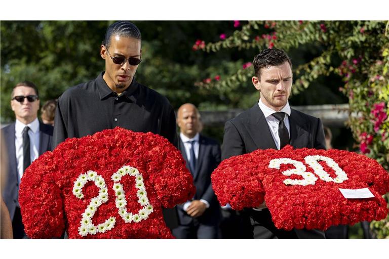 Bestritten mit Diogo Jota viele Partien beim FC Liverpool: Virgil Van Dijk (links) und Andy Roberston trauern. Sie tragen Blumen, welche die Rückennummern Jotas (20) und seines Bruders André (30 zeigen.