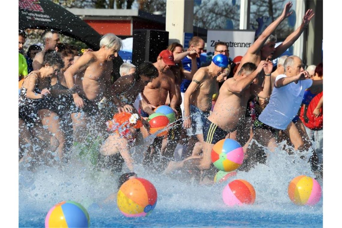 Frühes Freibad: In Karlsruhe schon die ersten Schwimmer Besucher des Freibad „Sonnenbad“ springen zur Eröffnung des Freibads in das Wasser des Beckens. Foto: Uli Deck/dpa