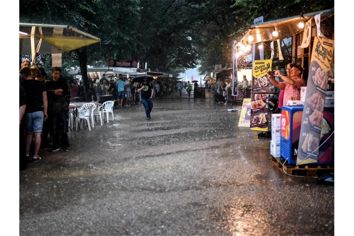 Gewitter treffen Teile Deutschlands Besucher des Internationalen Berliner Bierfestivals stellen sich bei starkem Regen unter Bäumen und bei Bierständen unter. Foto: Britta Pedersen