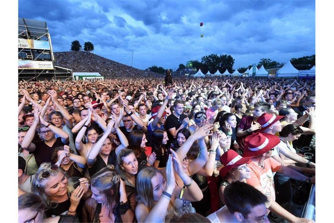 Auch das Karlsruher „Fest“ wegen Corona abgesagt Besucher des Open-Air-Festivals „Das Fest“ verfolgen in der Günther-Klotz-Anlage den Auftritt einer Band.. Foto: Uli Deck/dpa/Archivbild