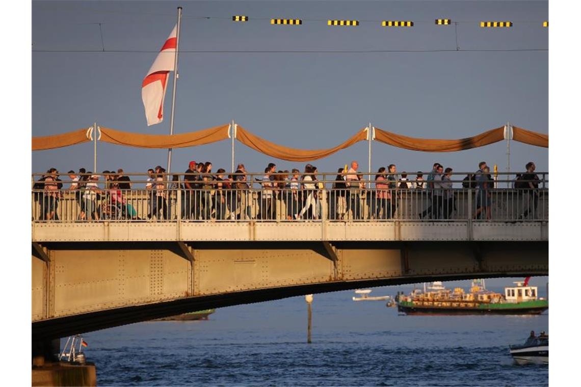 Seenachtfest: 40 000 Menschen nehmen Abschied vom Feuerwerk Besucher des Seenachtfestes laufen über die im Abendlicht liegende Rheinbrücke. Foto: Karl-Josef Hildenbrand