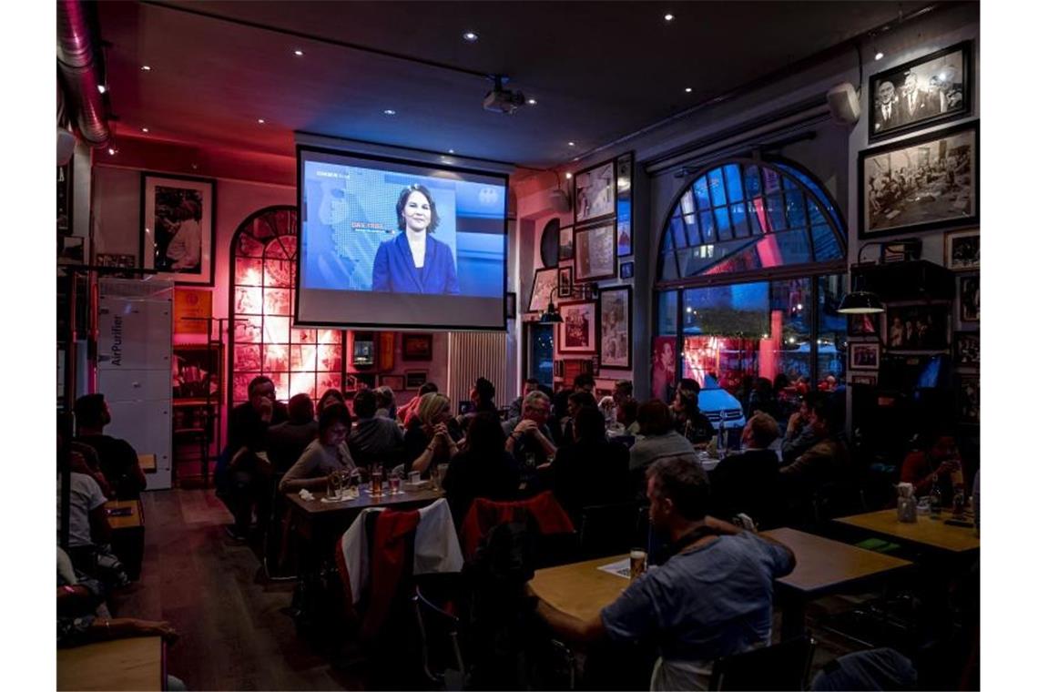 Kanzlerkandidaten zeigen sich im TV-Triell kämpferisch Besucher einer Berliner Kneipe schauen sich das TV-Triell an. Foto: Fabian Sommer/dpa