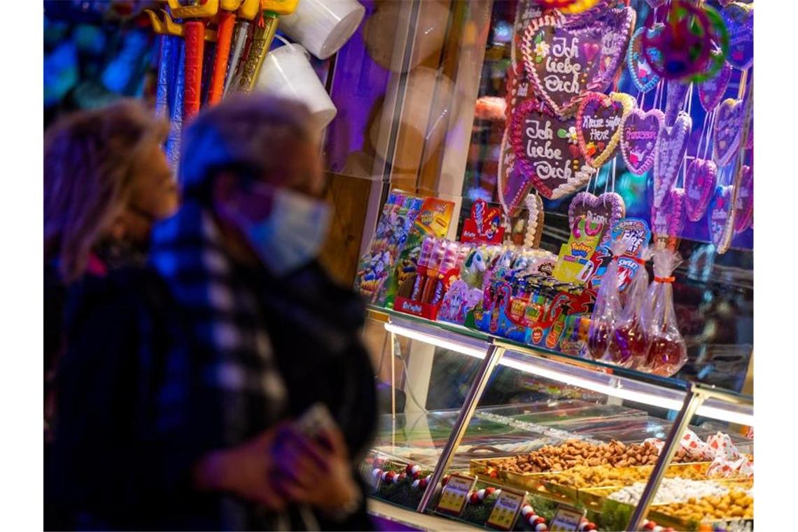 Besucher eines Weihnachtsmarktes stehen vor einem Süßigkeitenstand. Foto: Monika Skolimowska/dpa-Zentralbild/ZB/Symbolbild