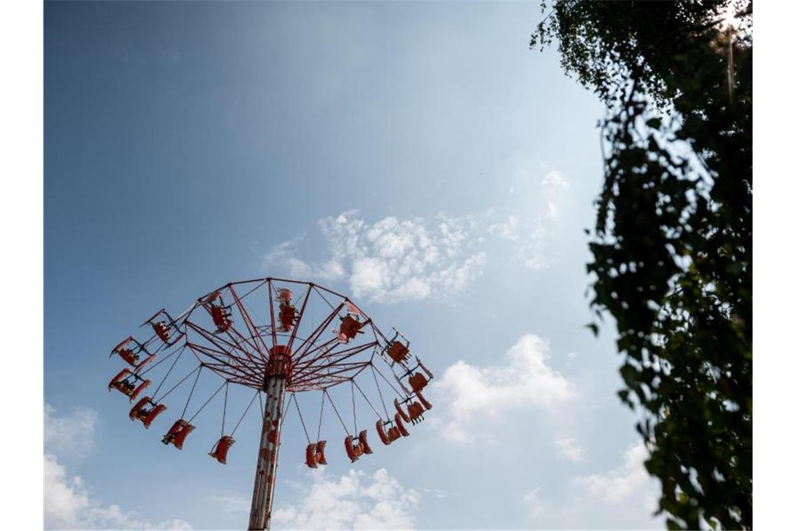 Besucher fahren in einem Fahrgeschäft in einem Freizeitpark. Foto: Fabian Strauch/dpa