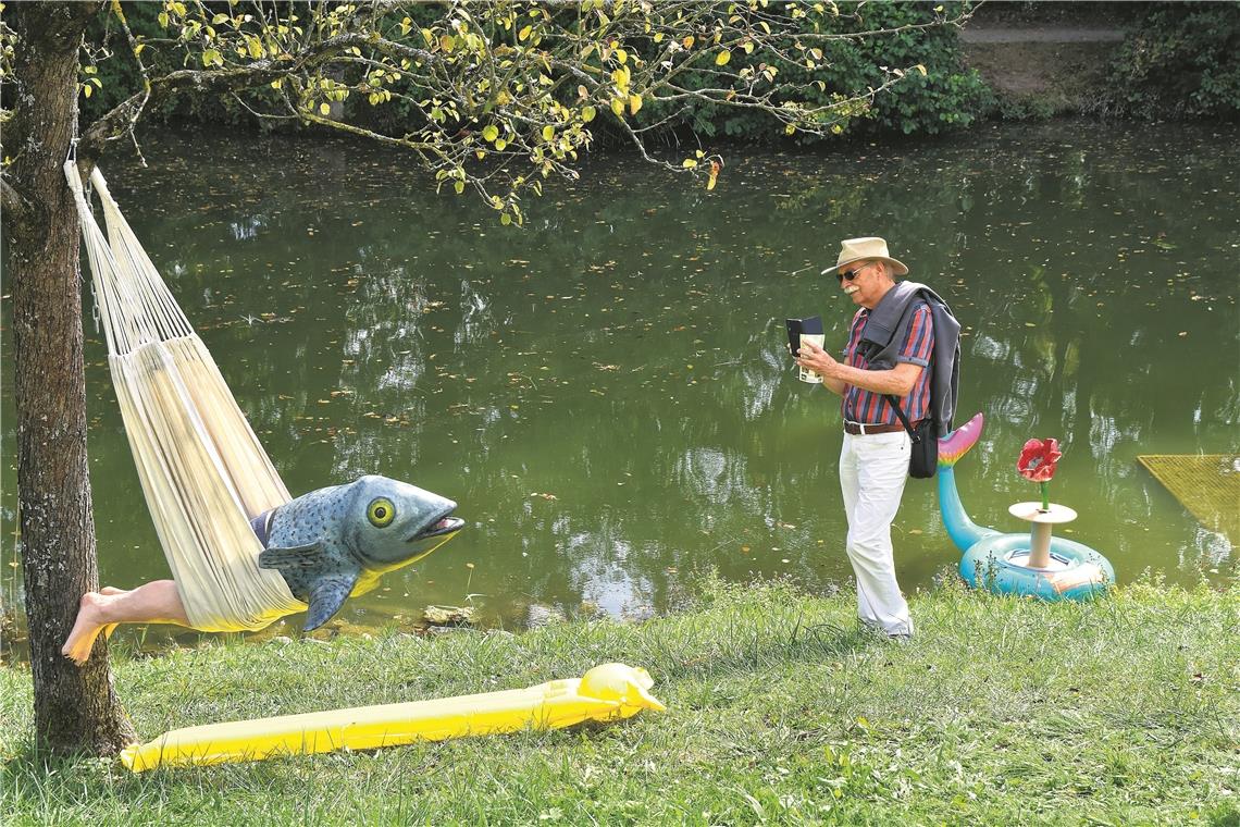 Kunst in idyllischer Kulisse Besucher Fraser Hillian aus Backnang hält das außergewöhnliche Kunstwerk „Fischmann“ von Verena Braunstein am Schlossteich mit dem Smartphone fest. Andrea Bühner, Lydia Feulner-Bärtele und Verena Braunstein thematisieren „Fremde“ in einer Gemeinschaftspräsentation. Fotos: T. Sellmaier