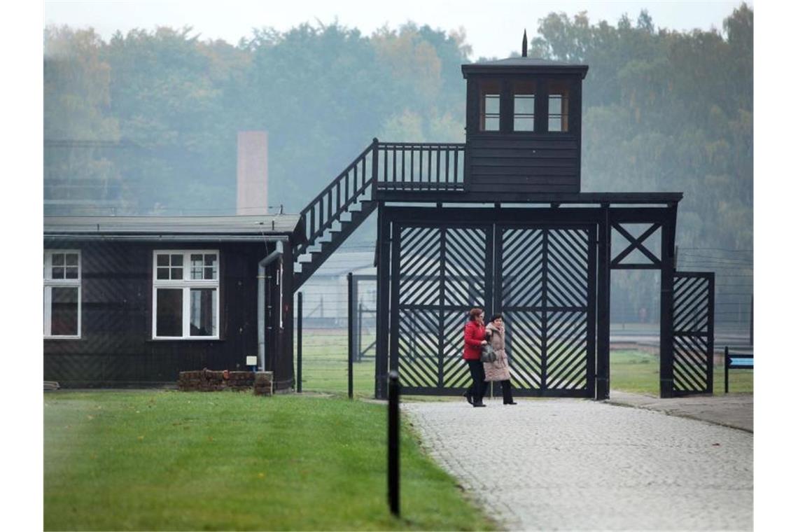 Besucher gehen am Eingang des Stutthof Museums in Sztutowo (Polen) vorbei, in dem an die Verbrechen im ehemaligen deutschen Konzentrationslager Stutthof erinnert wird. Foto: Piotr Wittman/PAP/dpa