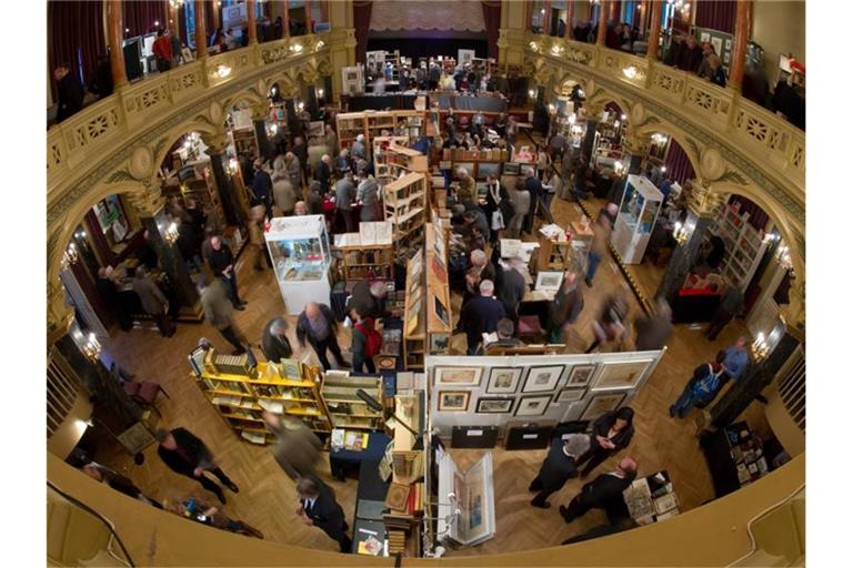 Besucher gehen bei der 25. Antiquariatsmesse an den Messeständen vorbei. Foto: picture alliance/dpa/Archivbild