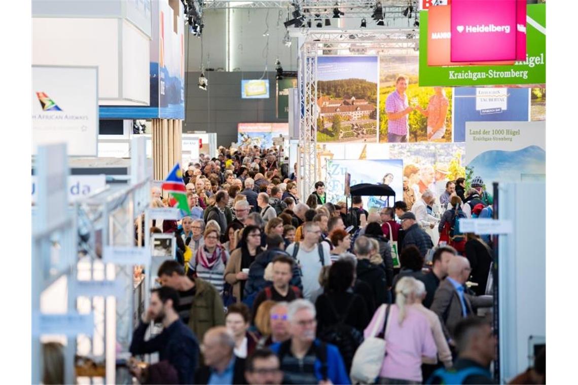 Besucher gehen bei der Reisemesse CMT durch eine Halle der Messe Stuttgart. Foto: Tom Weller/dpa