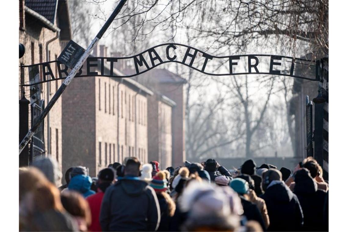 Warnungen und Mahnungen zur Gedenkfeier in Auschwitz Besucher gehen durch den Eingang mit dem Schriftzug „Arbeit macht frei“ in das frühere Konzentrationslager Auschwitz in Oswiecim. Foto: Kay Nietfeld/dpa