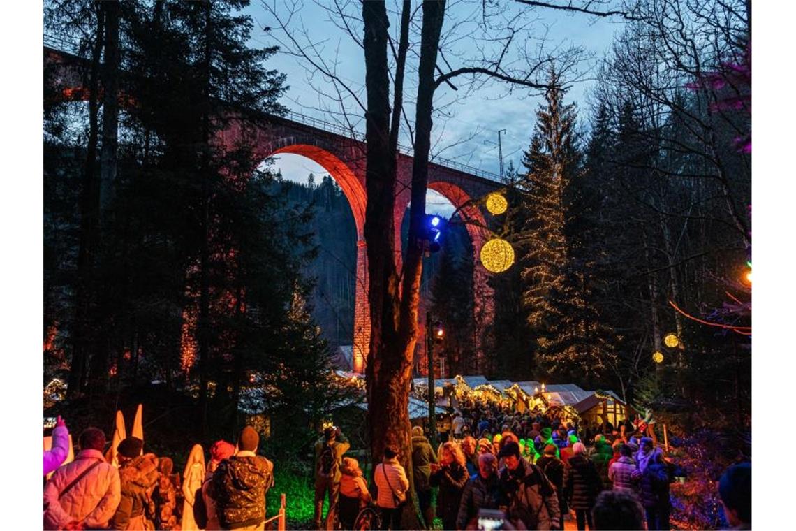 Besucher gehen über den Weihnachtsmarkt unter dem Aquädukt in der Ravennaschlucht. Foto: Philipp von Ditfurth/dpa