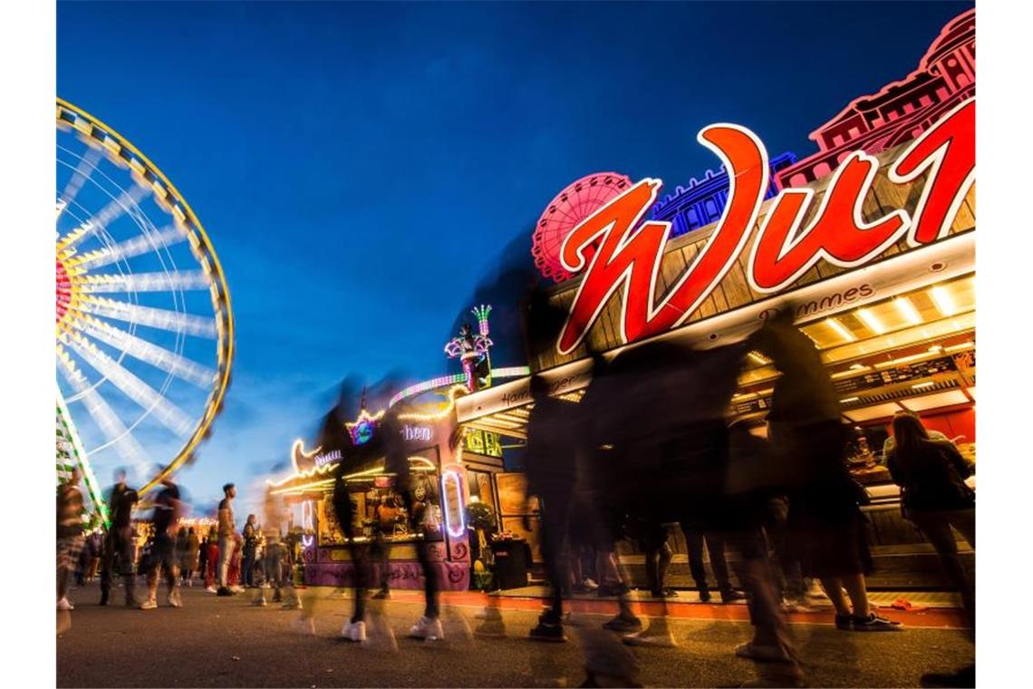 Besucher genießen zur blauen Stunde das 81. Stuttgarter Frühlingsfest auf dem Cannstatter Wasen. Foto: Christoph Schmidt/dpa/Archivbild