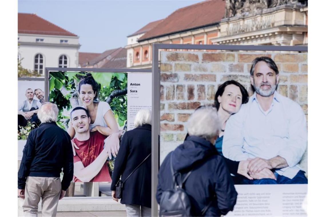 Besucher schauen sich in Potsdam die Fotoausstellung „30 Jahre – 30 Paare“ an, welche Teil der Freiluftausstellung EinheitsEXPO ist. Foto: Christoph Soeder/dpa