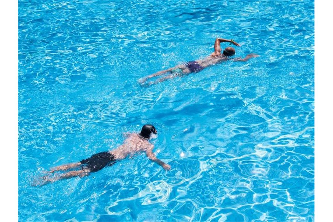 Besucher schwimmen in einem Freibad. Foto: Daniel Bockwoldt/dpa/Symbolbild