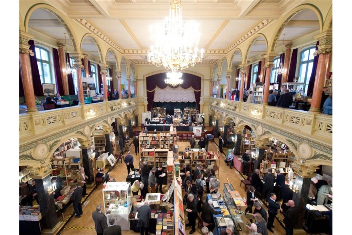 Besucher sehen sich bei der 28. Antiquariatsmesse „Antiquaria“ die Exponate an den Ständen an. Foto: picture alliance/Sebastian Kahnert/dpa/Archivbild