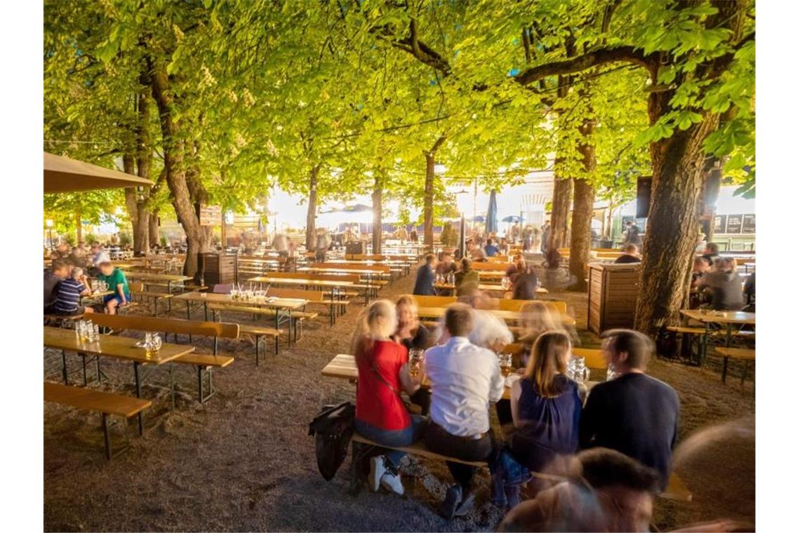 Besucher sitzen im Biergarten: Bayern überlegt auch Innen wieder zu öffnen. Foto: Peter Kneffel/dpa