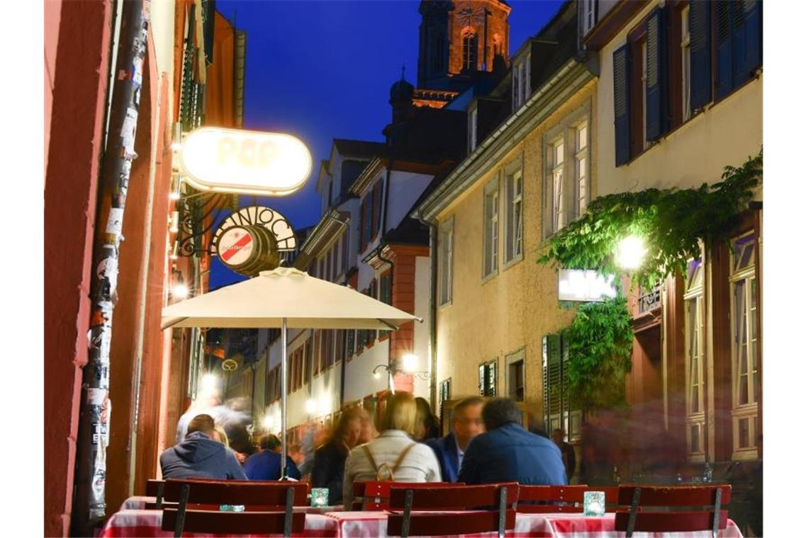 Lärmgeplagte Heidelberger erringen mehr Nachtruhe Besucher sitzen in der Altstadt in der Unteren Strasse an Tischen. Foto: Uwe Anspach/Archivbild
